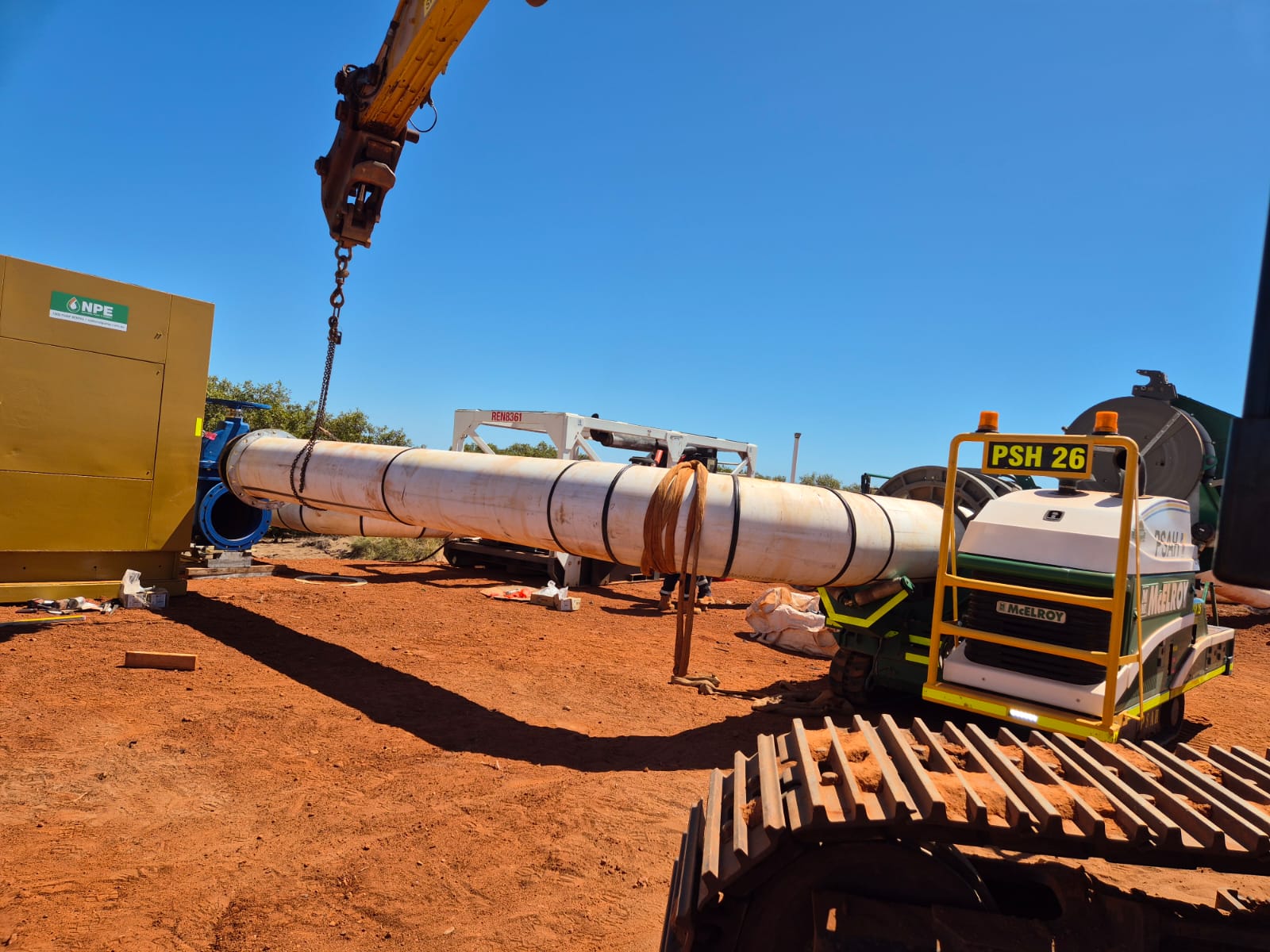 Loader lifting a large fabricated HDPE bend on a civil project