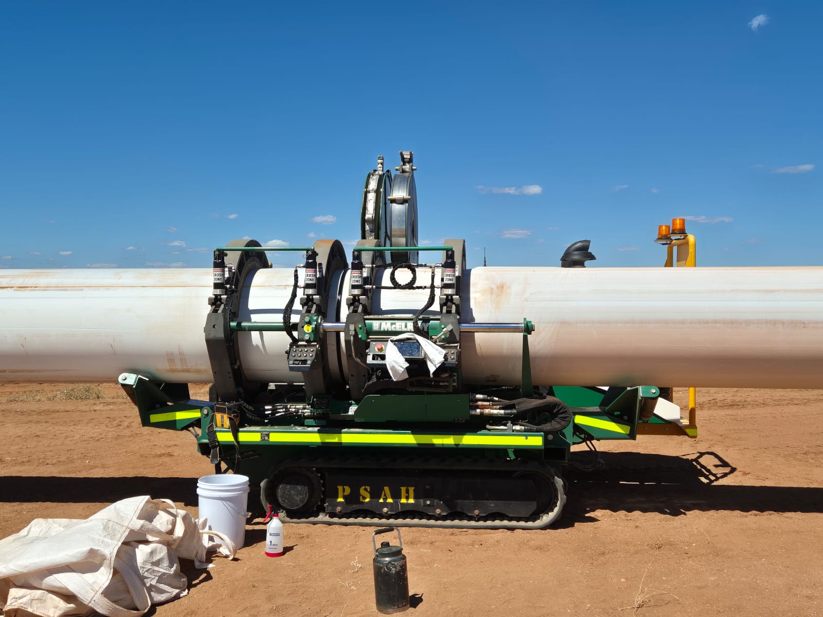 McElroy fusion machine and white HDPE pipe under an open sky